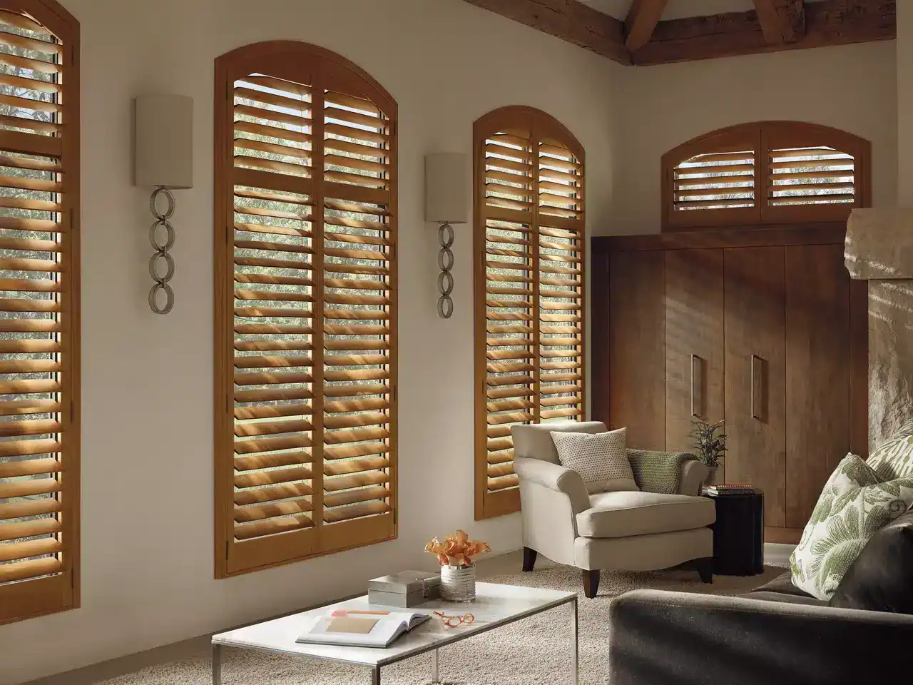 Wooden plantation shutters with adjustable louvers for natural light control and privacy in a cozy living room setting.