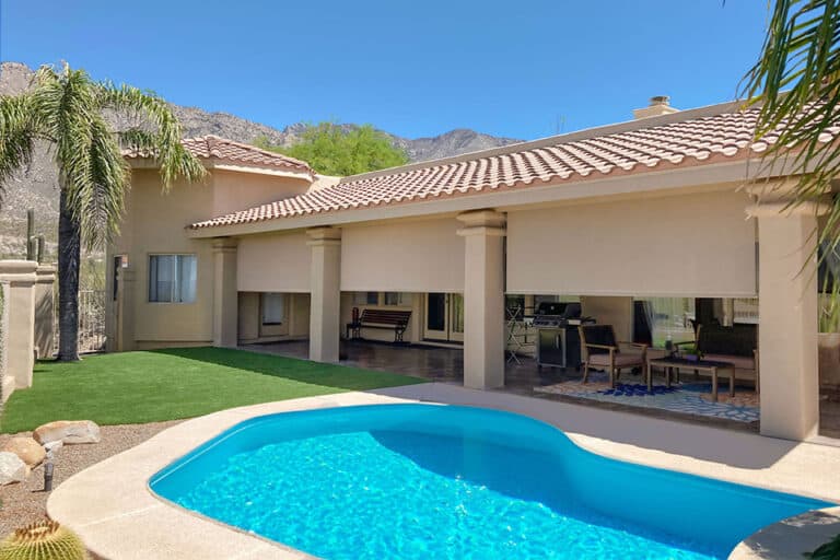 Luxurious window blinds installed on a modern house with a backyard pool, providing privacy and shade, perfect for outdoor living spaces.