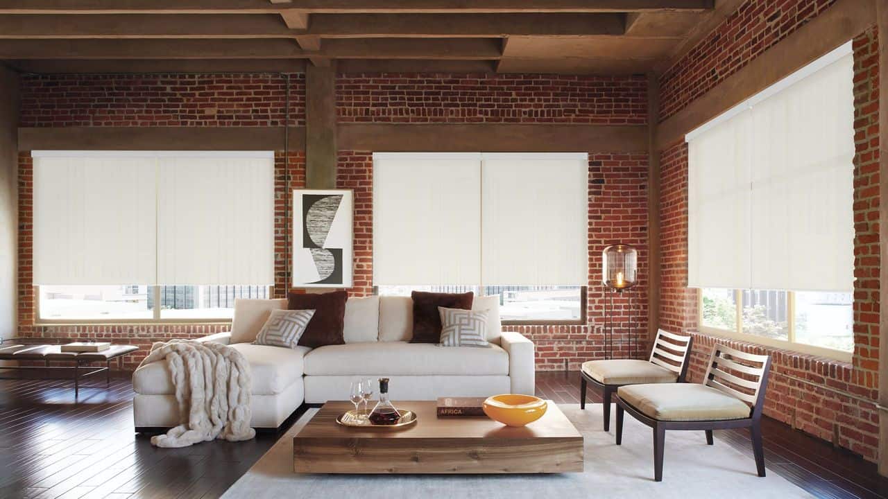 Stylish beige window blinds in modern loft living room with exposed brick walls and wooden ceiling beams. Perfect for enhancing natural light control and privacy.
