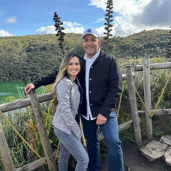 Beautiful couple enjoying outdoor scenery with lush green hills and lake, showcasing the natural environment for outdoor window treatment ideas from Superior Blinds.
