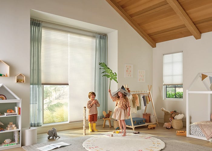 Bright white and light-colored blinds installed in a cozy children's bedroom with large windows and natural light.