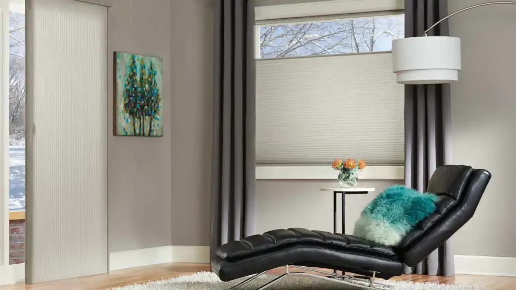 Light-filtering beige window shades with dark gray drapes in a modern living room setting.