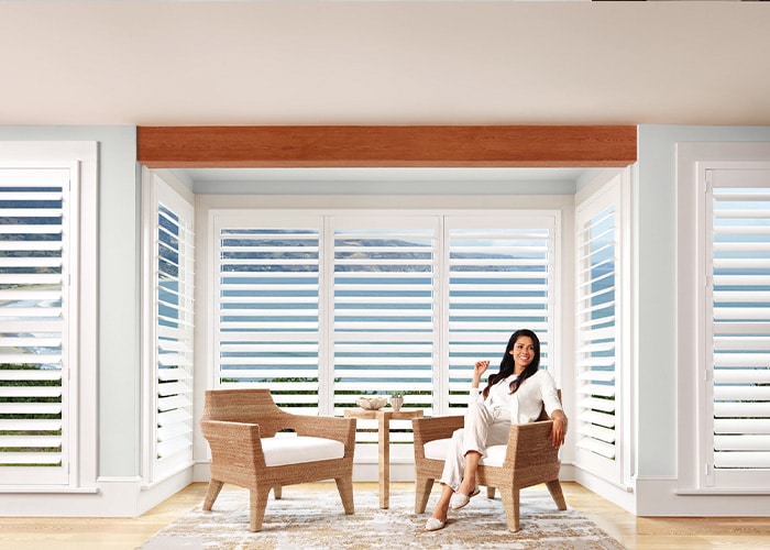 Luxury white plantation shutters on large windows, modern interior design, natural light, stylish window treatments, superior blinds, home decor, energy-efficient window coverings.
