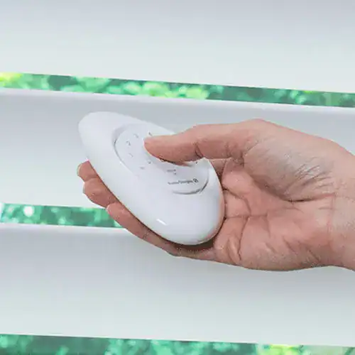 Deluxe motorized blind control with handheld remote, sleek white design, easy operation for window blinds, perfect for modern homes seeking smart window treatment solutions.