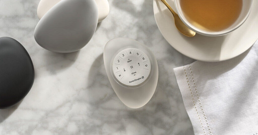 Sleek modern egg-shaped smart home device on a marble surface with eggs and tea, showcasing innovative home automation solutions.