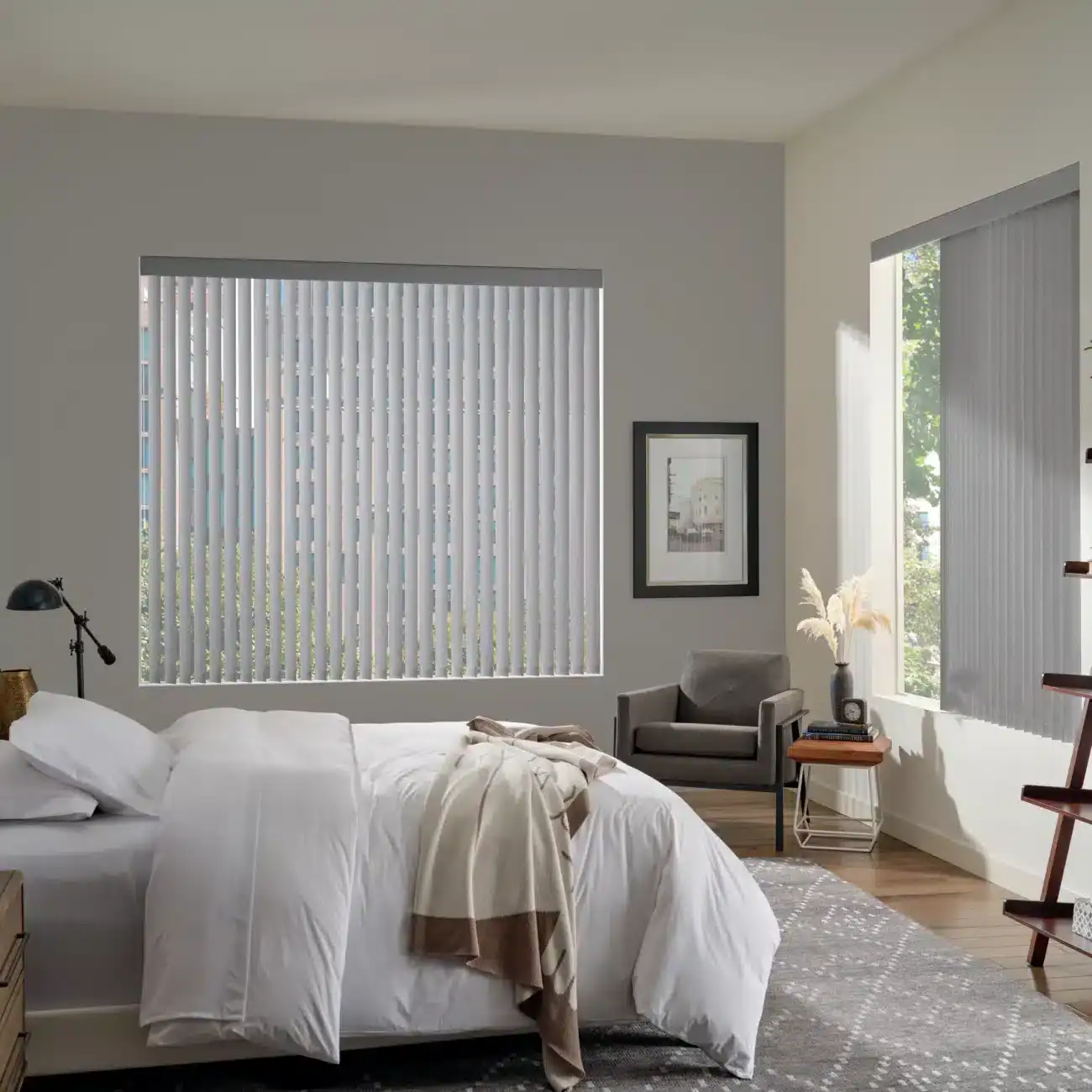 Vertical white window blinds installed in a modern bedroom with a cozy bed, stylish decor, and natural light. Ideal for privacy and light control, perfect for home interior upgrades.