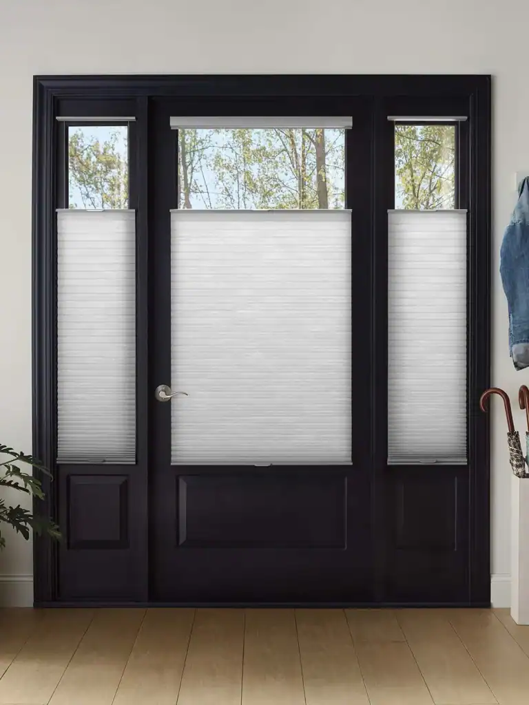 Luxurious black door with white textured cellular blinds, enhancing natural light and privacy, ideal for stylish home windows and patio doors.