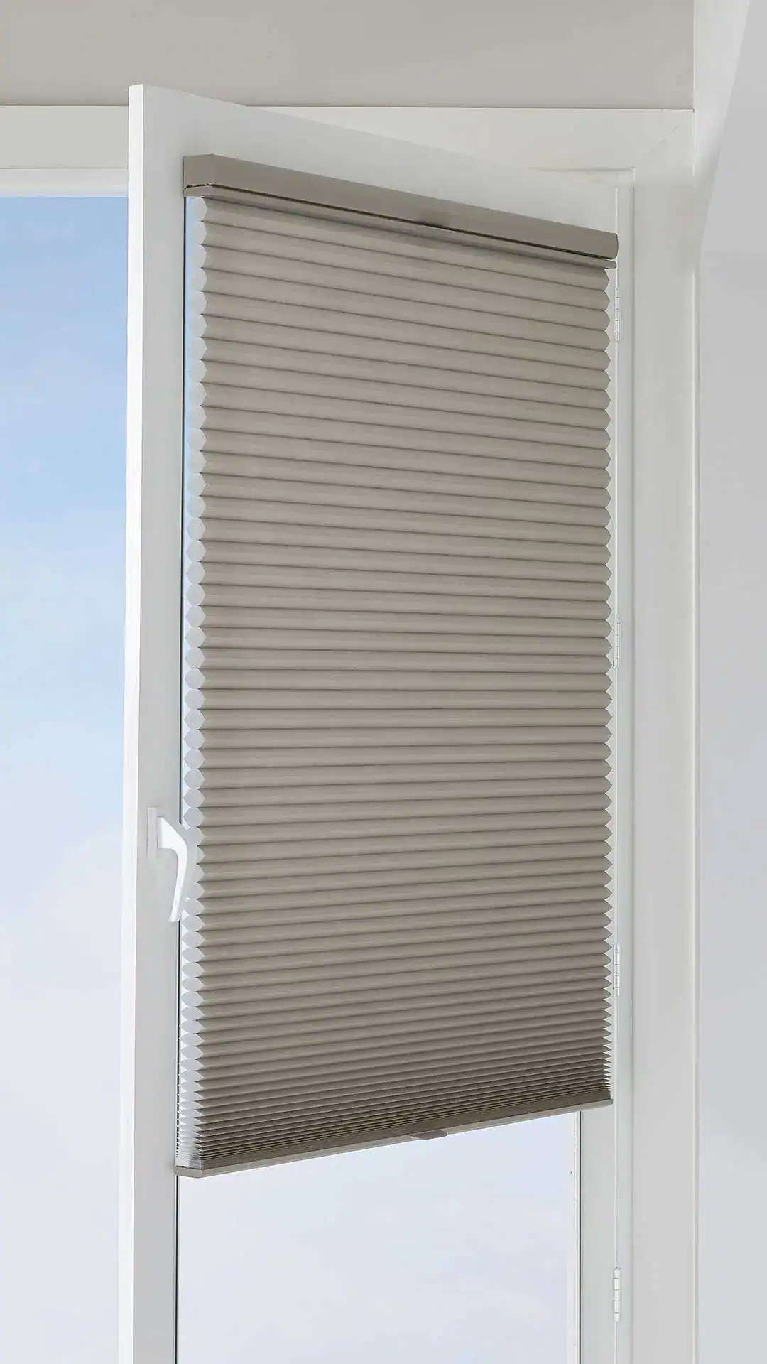 Neutral beige cordless window blind with a sleek white frame, providing light control and privacy for modern homes. Customizable for various window sizes, enhancing interior decor with practicality.