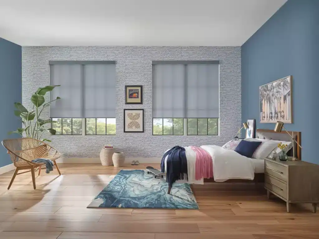Sleek white roller shades installed in a modern bedroom with blue accent walls, providing elegant window coverage for light control and privacy.