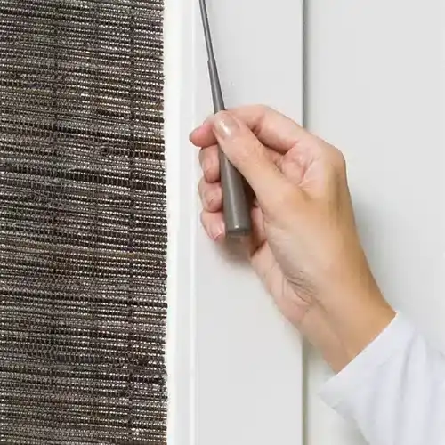 Precision installation of custom window blinds with expert tools and craftsmanship for superior window covering solutions.